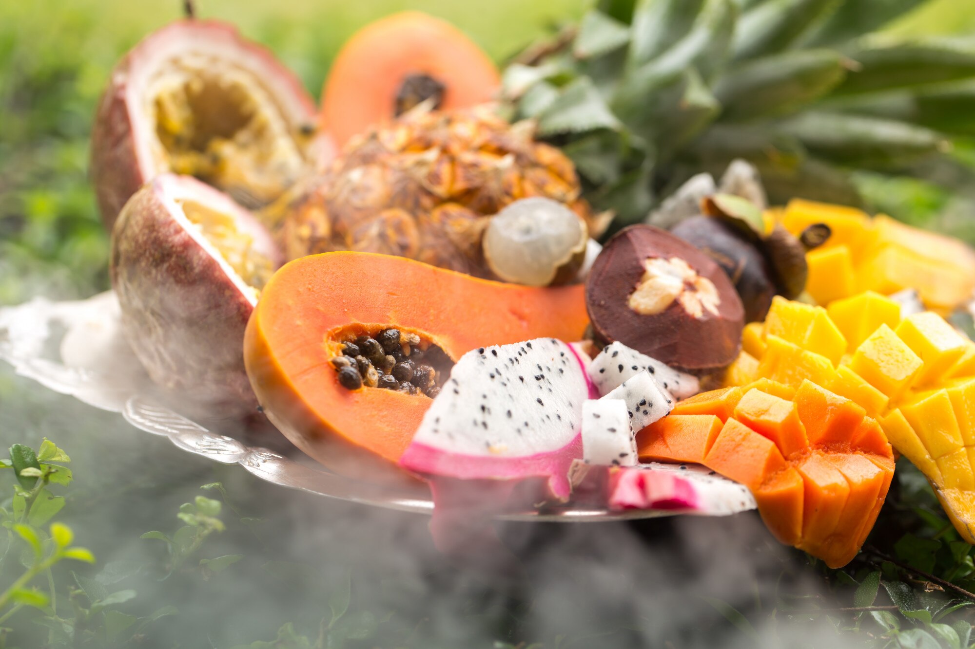 Assortment of fresh tropical fruits including papaya, guava, and berries arranged on a wooden table
